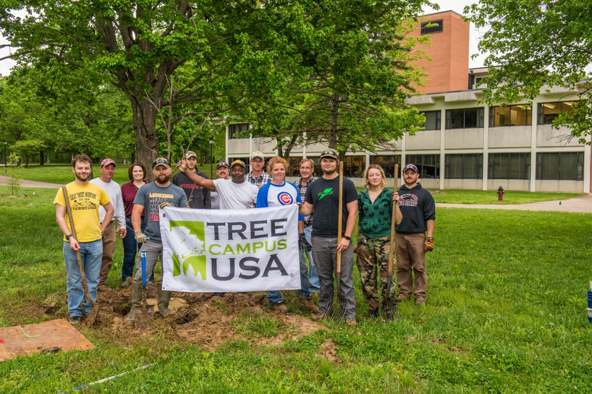 group of people holding up a Tree Campus USA banner