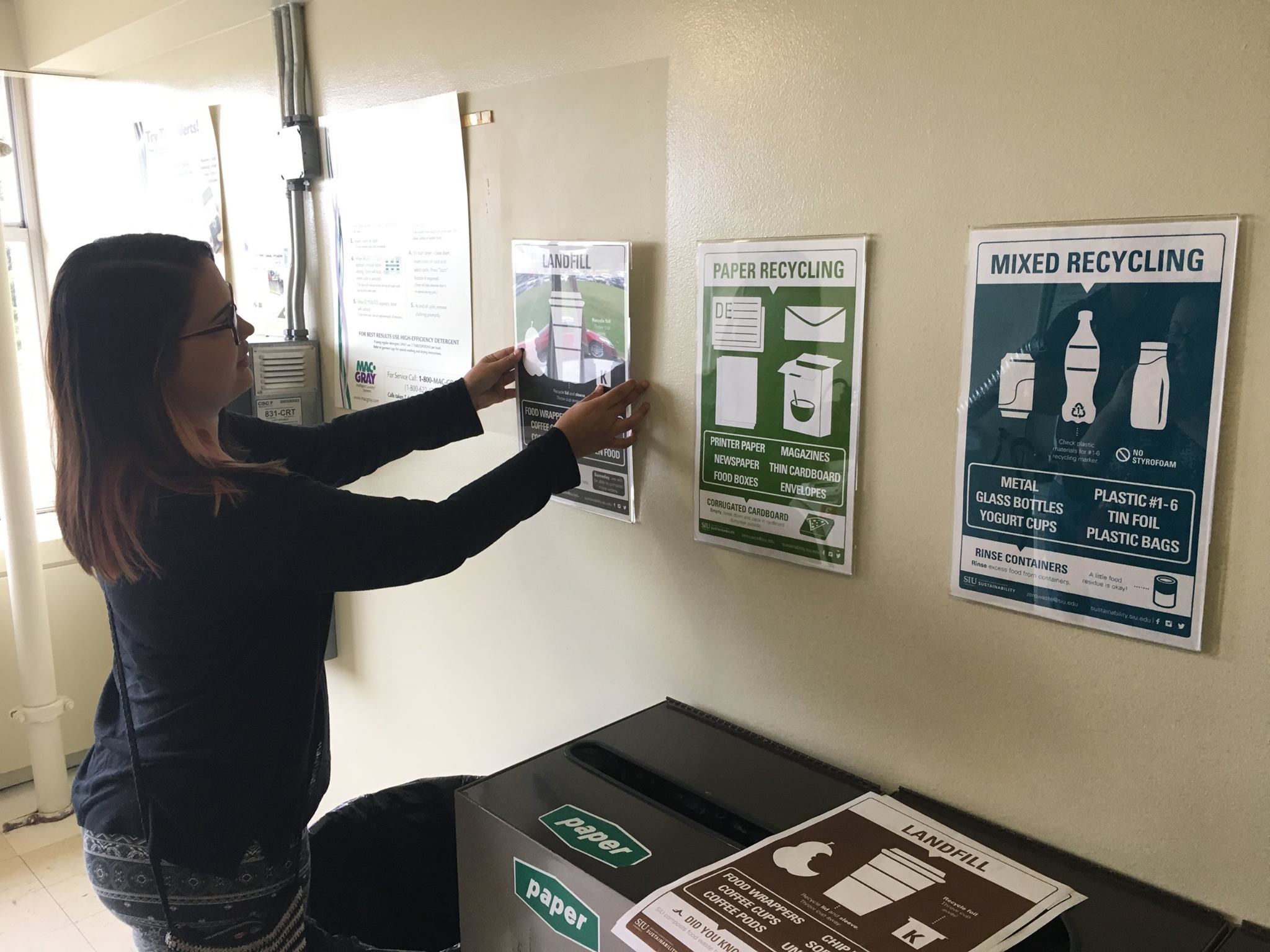 AIGA Student Putting Up Waste and Recycling Signs