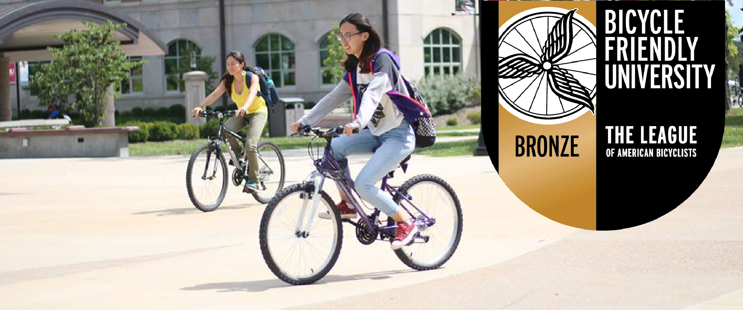 a bicyclist enjoys campus, bicycle friendly university symbol included