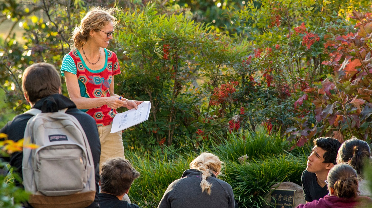 Students and professor having class outside.