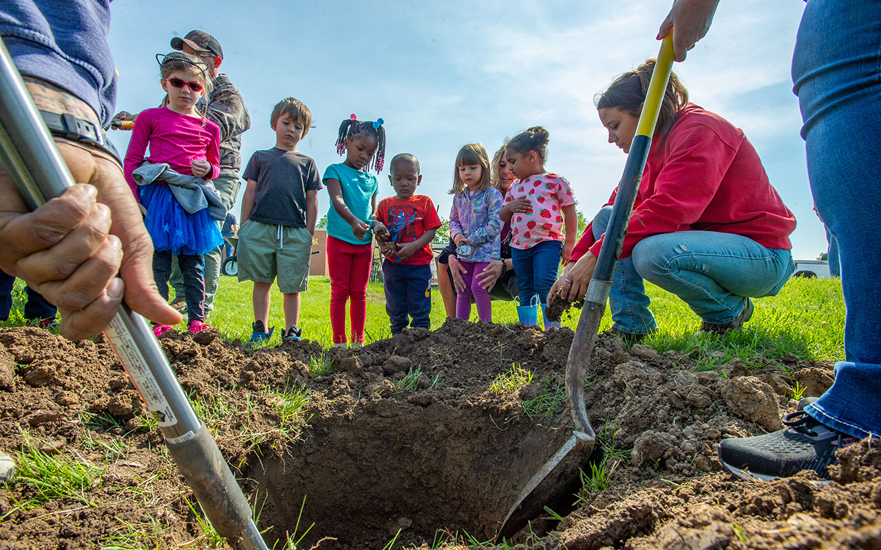 Group of children watch a tree being planted on the SIU campus