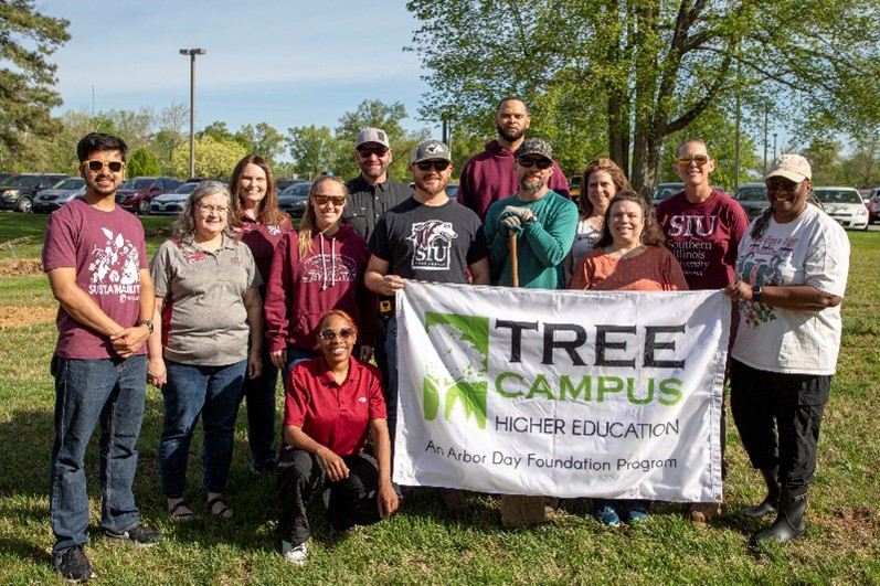 Tree Campus group holding up a tree campus higher education banner