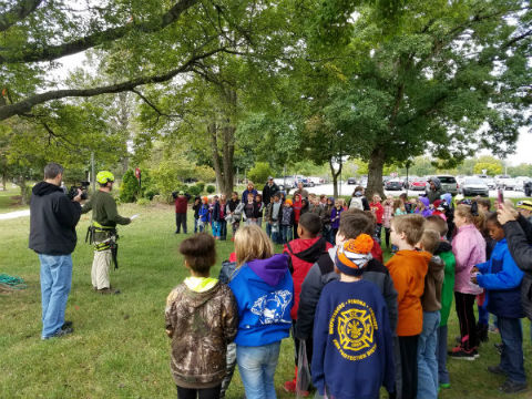 tree walk 4th graders standing watching a presentation