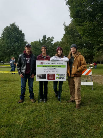 tree walk and demonstration group with the SIU tree campus sign