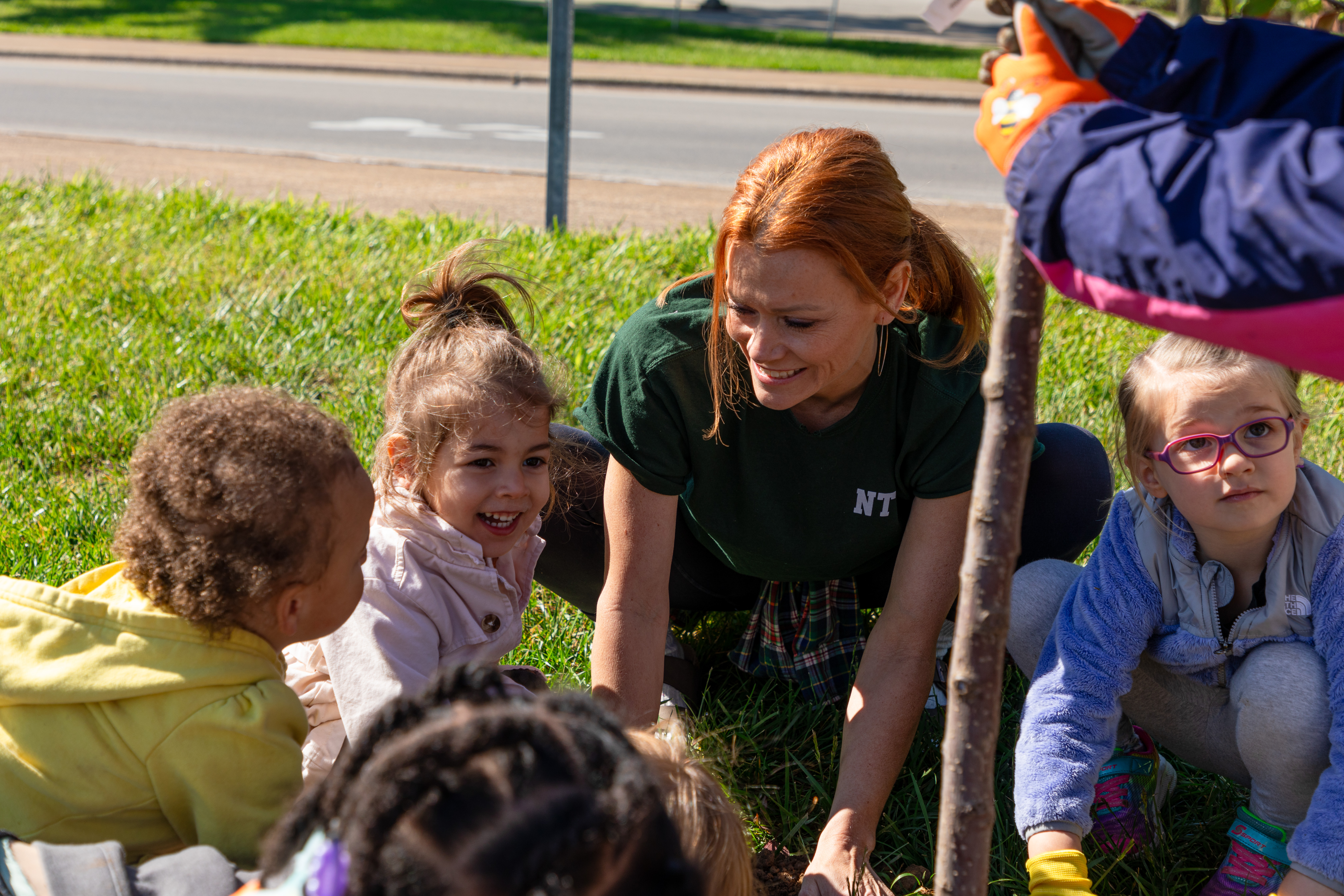 woman planting a tree with kids